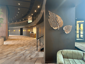 a lobby with a couch and a wall with two leaves on it